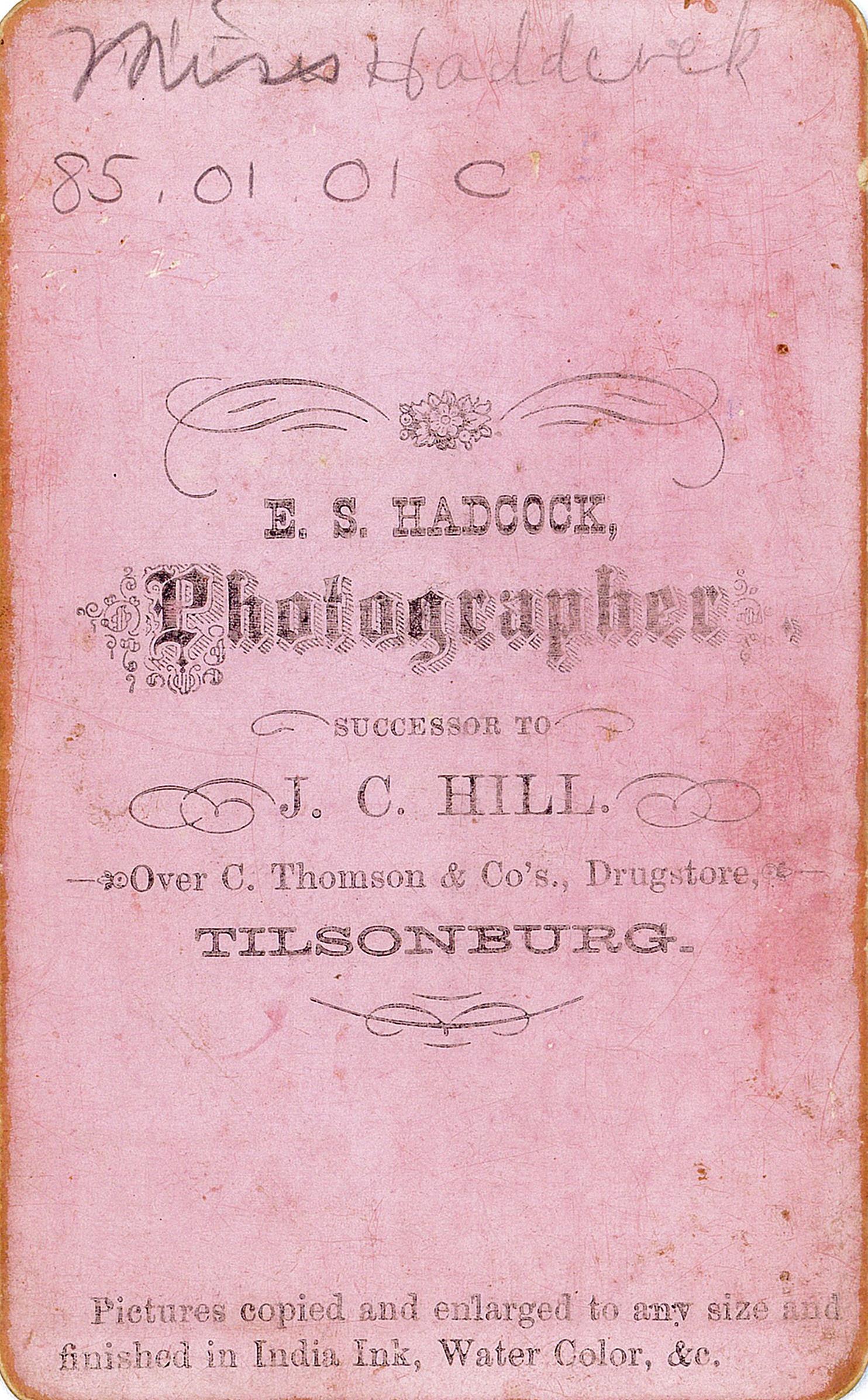 Back of a pink cabinet card from photographer E.S. Hadcock. 