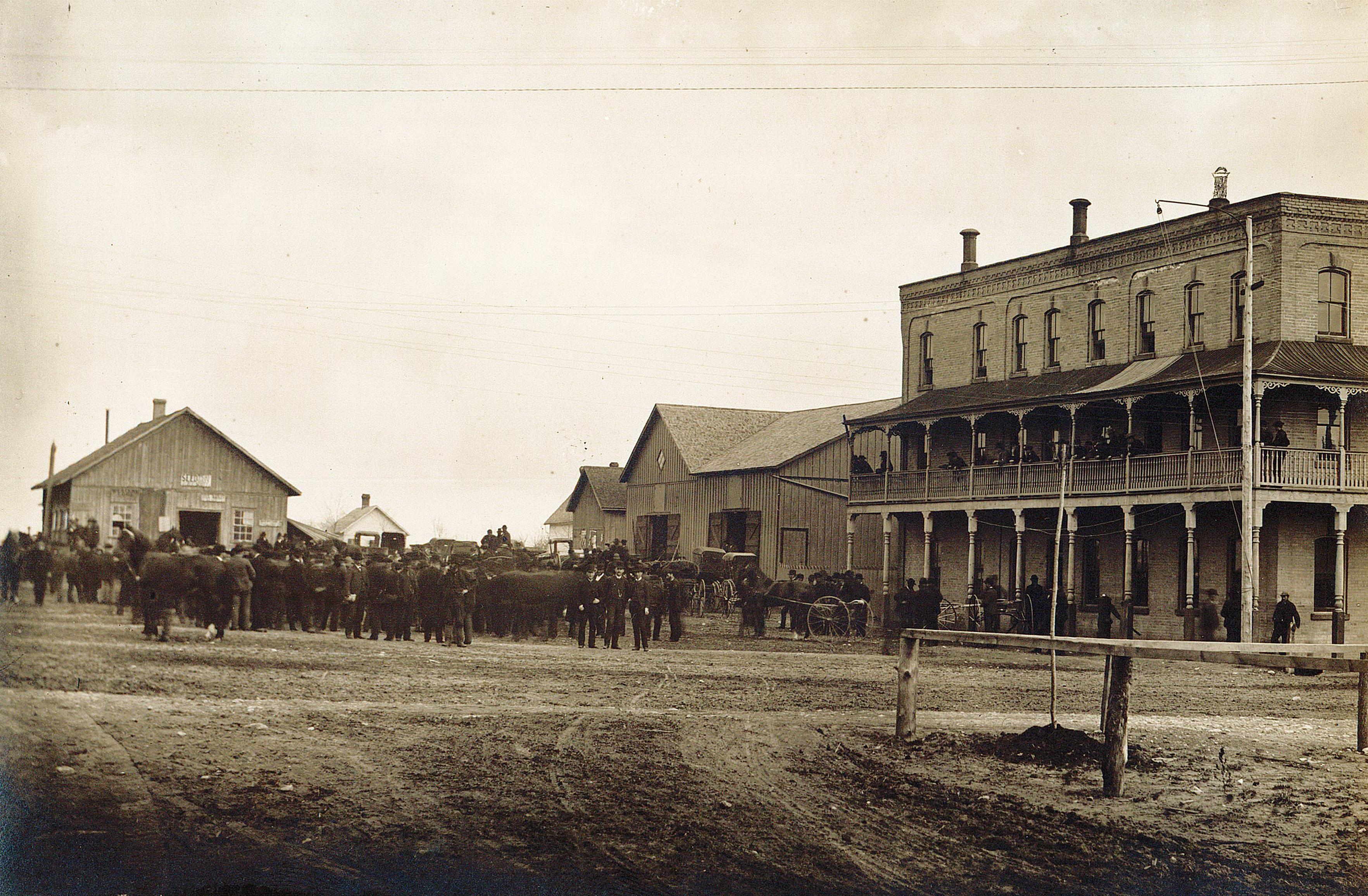 Photo of the Matheson House and market square in Tillsonburg. A crowd of people are in the square.