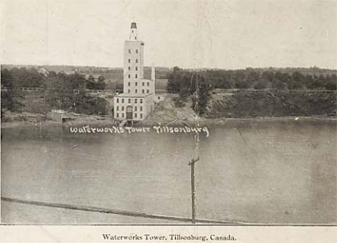 The water works tower in Tillsonburg. A large, light coloured brick tower sitting on the banks of a creek.