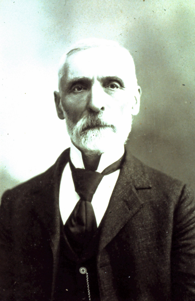Portrait of W.S. Law. Law has short white hair and beard. Wearing dark coloured jacket, vest, and tie.